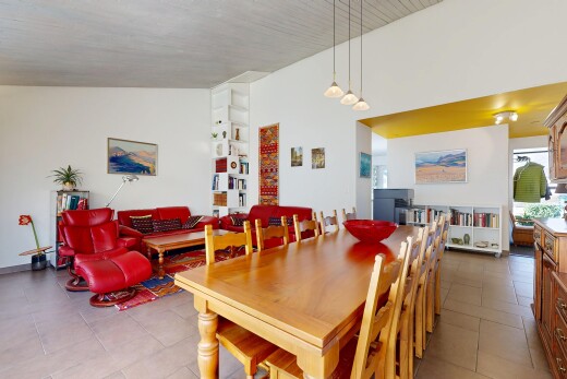 tiled living room featuring vaulted ceiling