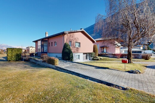 outdoor house featuring a mountain view and a lawn