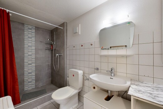 full bathroom with a stall shower, tile walls, and vanity
