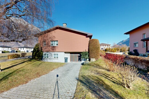 view of home featuring a chimney, a yard, and a mountain view