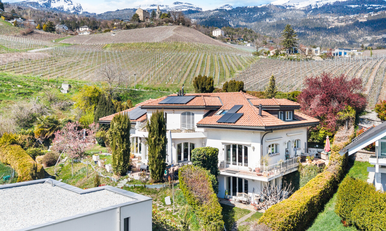 view of property featuring agricultural plots, roof mounted solar panels, and a mountain view