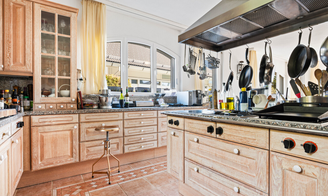 cuisine avec hotte, armoires marron clair, light brown cabinets, armoires élevées, et raised cabinets
