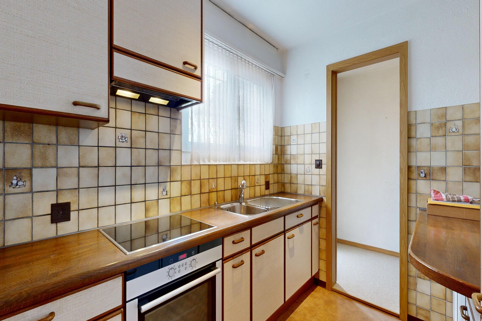 cuisine avec four, light floor, two tone kitchen, inside property, et plaque de cuisson