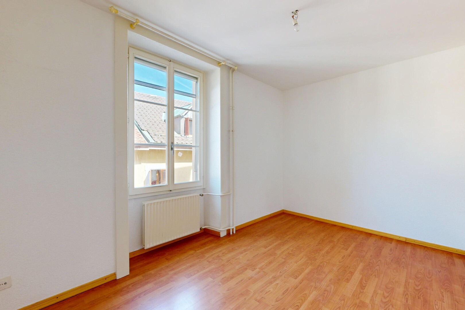 pièce vide avec cloison sèche, drywall, sol en finition bois, wood finish floor, et radiateur
