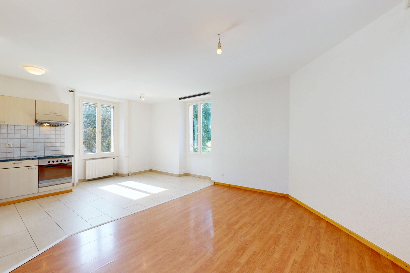 pièce vide avec backsplash, lumière naturelle, natural light, sol en finition bois, et wood finish floor