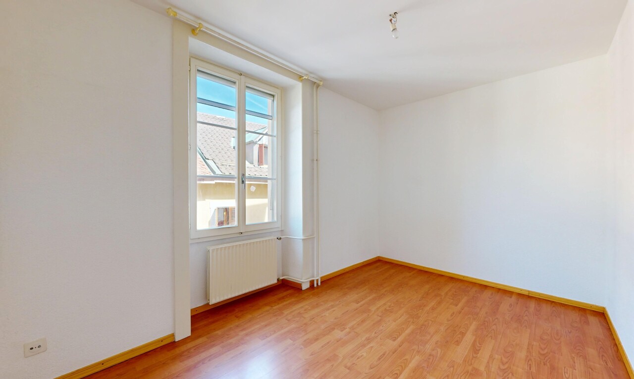 pièce vide avec cloison sèche, drywall, sol en finition bois, wood finish floor, et radiateur