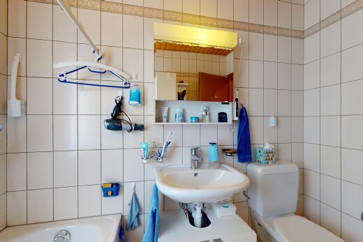 salle de bains avec mur en carrelage, tile wall, toilette, inside property, et bain