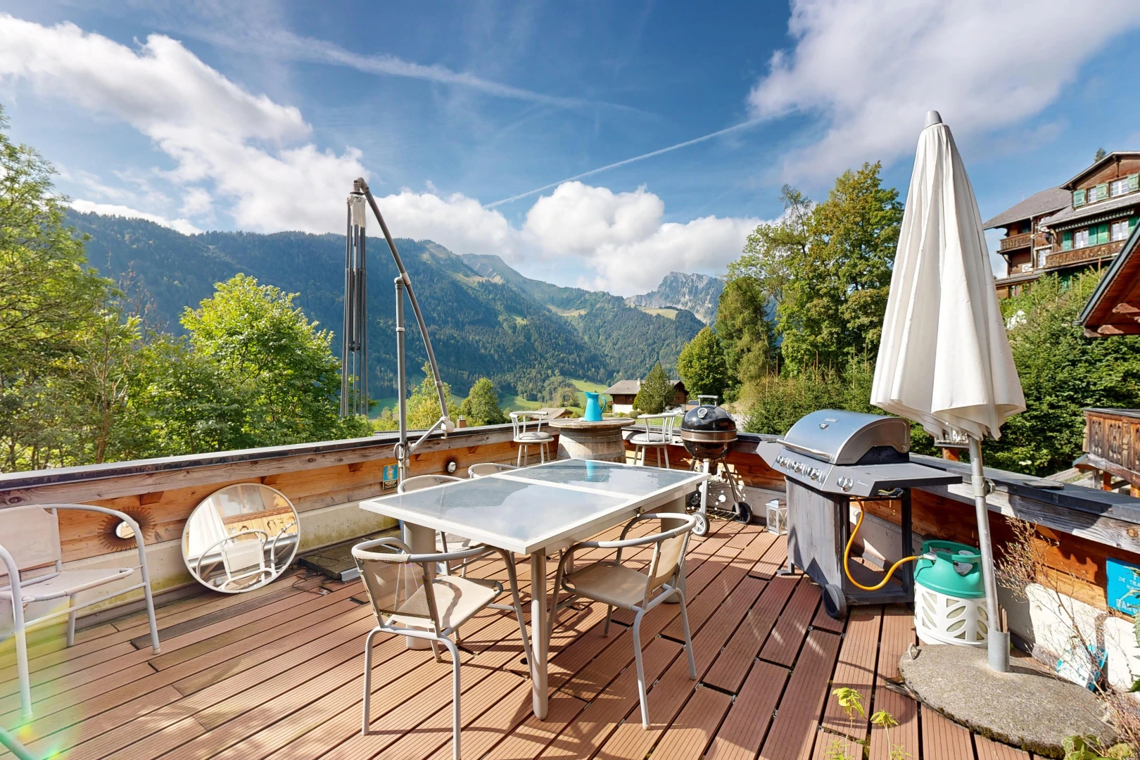 patio / terrace with a deck with mountain view, a grill, and outdoor dining area