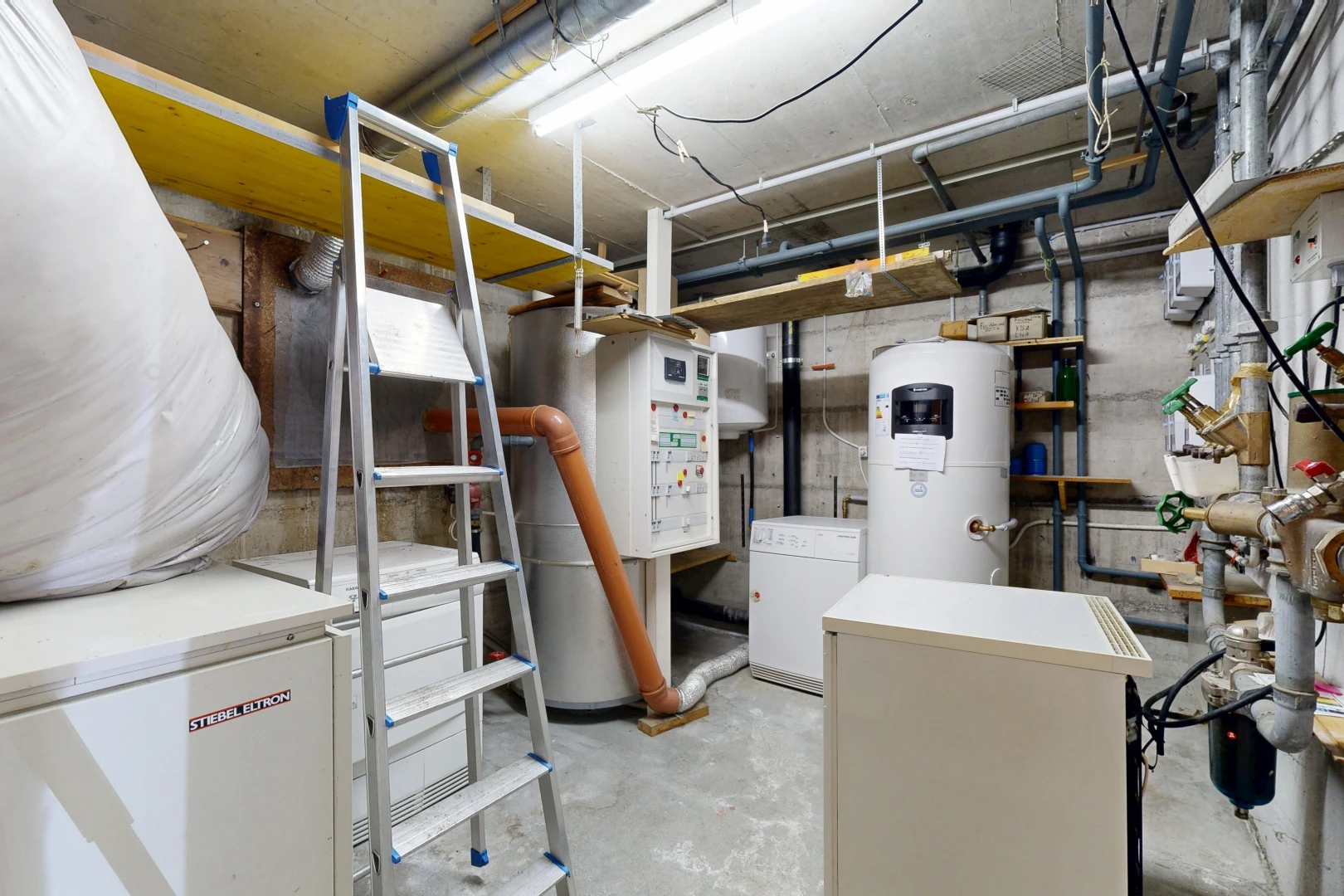 laundry area featuring water heater and concrete flooring