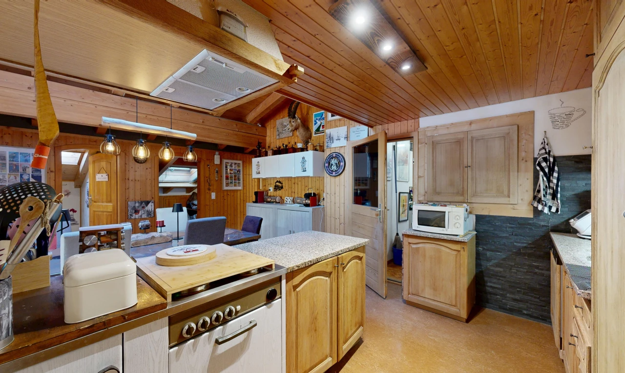 kitchen with wooden ceiling, rail lighting, white microwave, light countertops, and light wood finish cabinetry