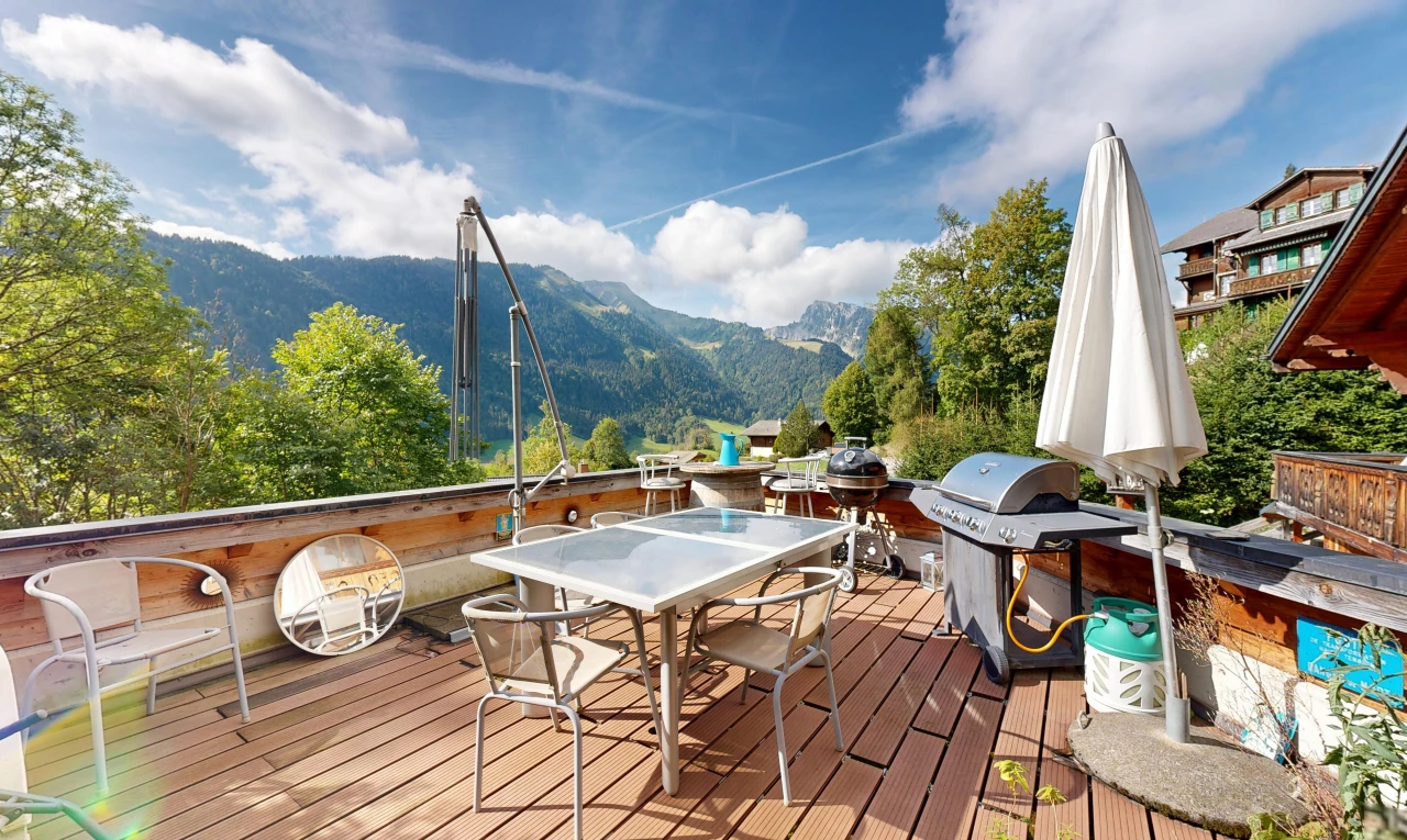 patio / terrace with a deck with mountain view, a grill, and outdoor dining area