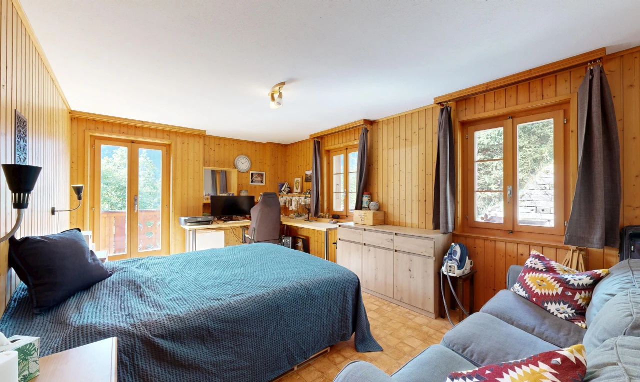 room with wooden walls, access to exterior, and a desk