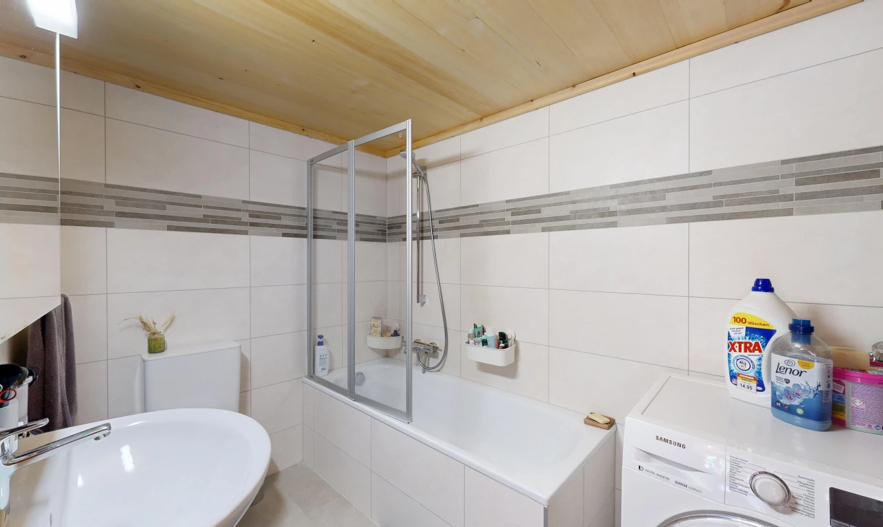 full bathroom with tile walls, washer / clothes dryer, and tiled shower / bath