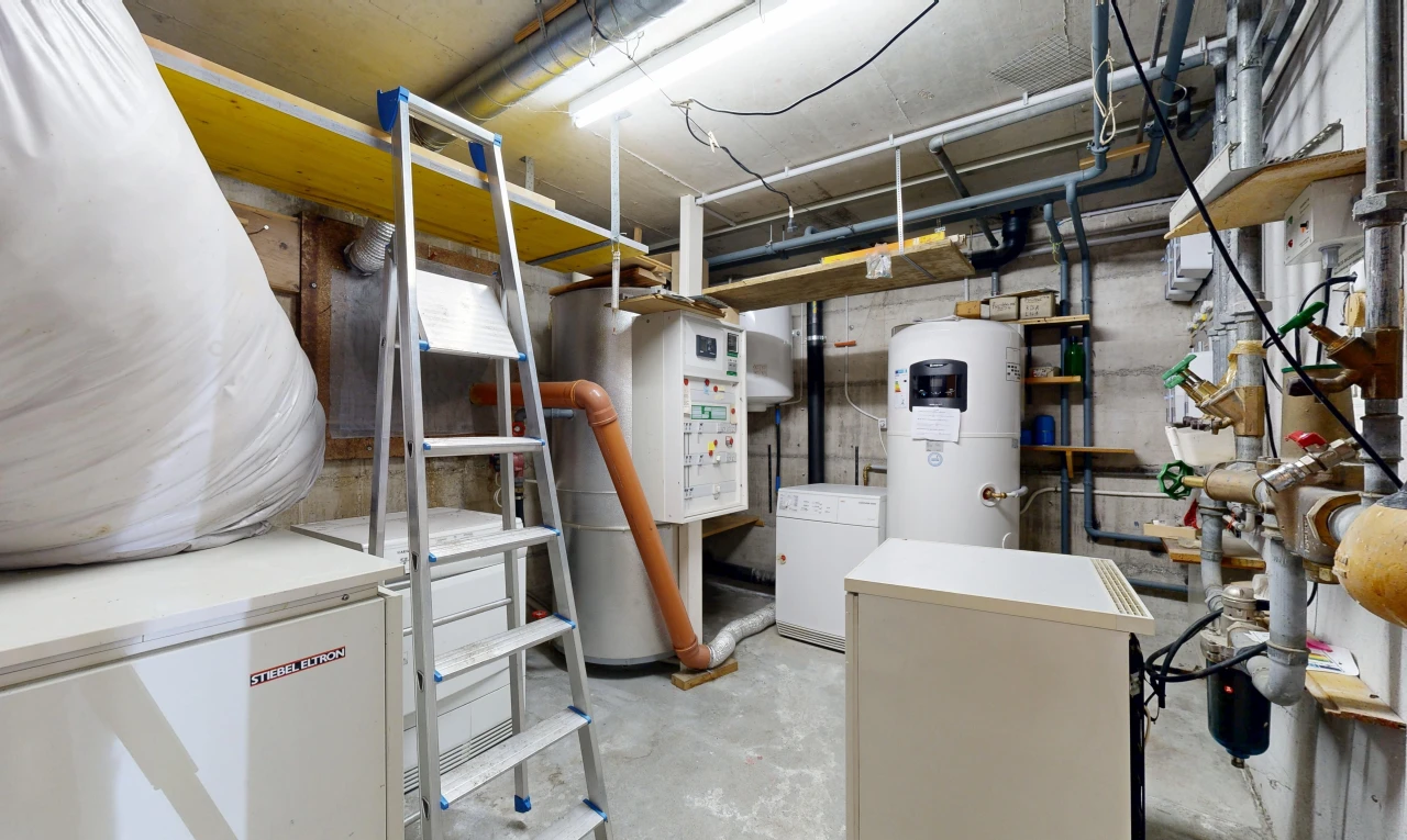 laundry area featuring water heater and concrete flooring
