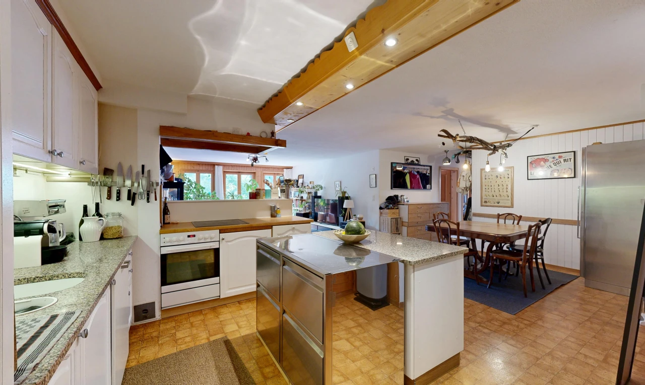 kitchen featuring a kitchen island, freestanding refrigerator, white cabinetry, and light stone countertops