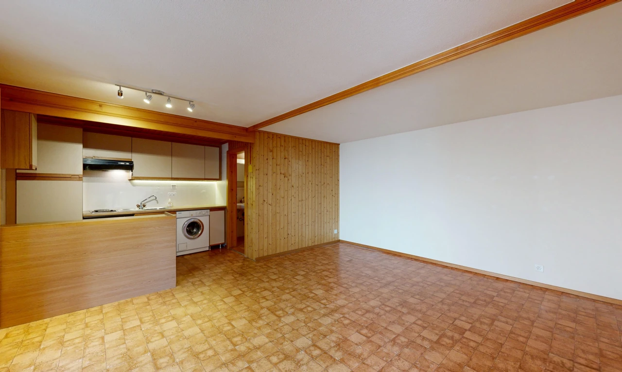 empty room featuring rail lighting, wooden walls, and washer / clothes dryer