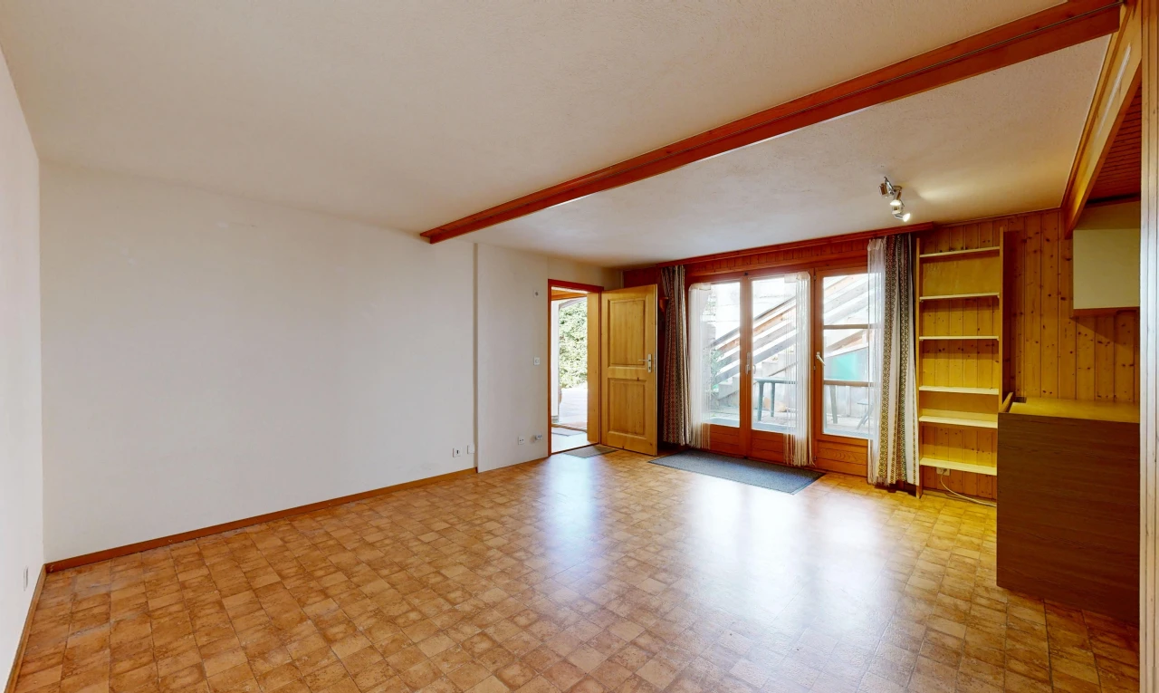unfurnished room featuring rail lighting, built in shelves, access to outside, beamed ceiling, and light flooring