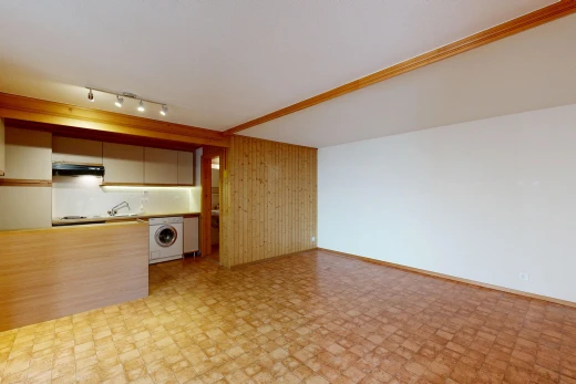 empty room featuring rail lighting, wooden walls, and washer / clothes dryer