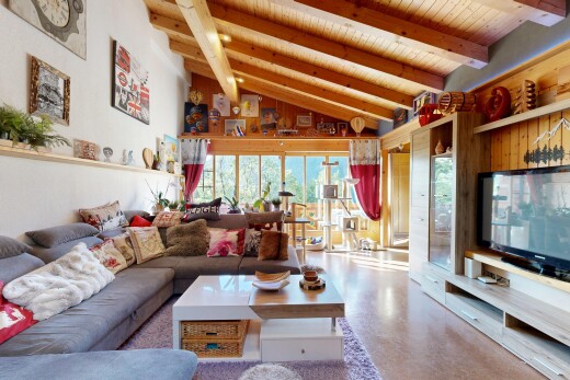 living room with a high wood beamed ceiling, built in shelves, and concrete flooring