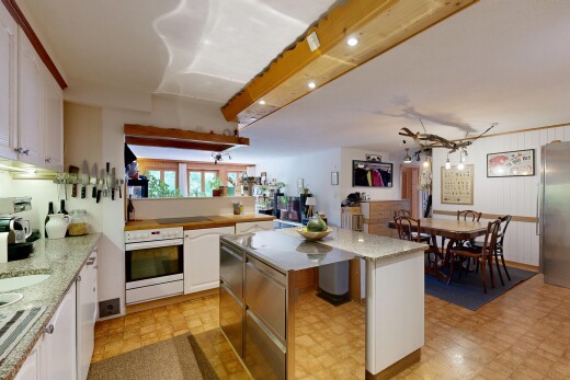 kitchen featuring a kitchen island, freestanding refrigerator, white cabinetry, and light stone countertops