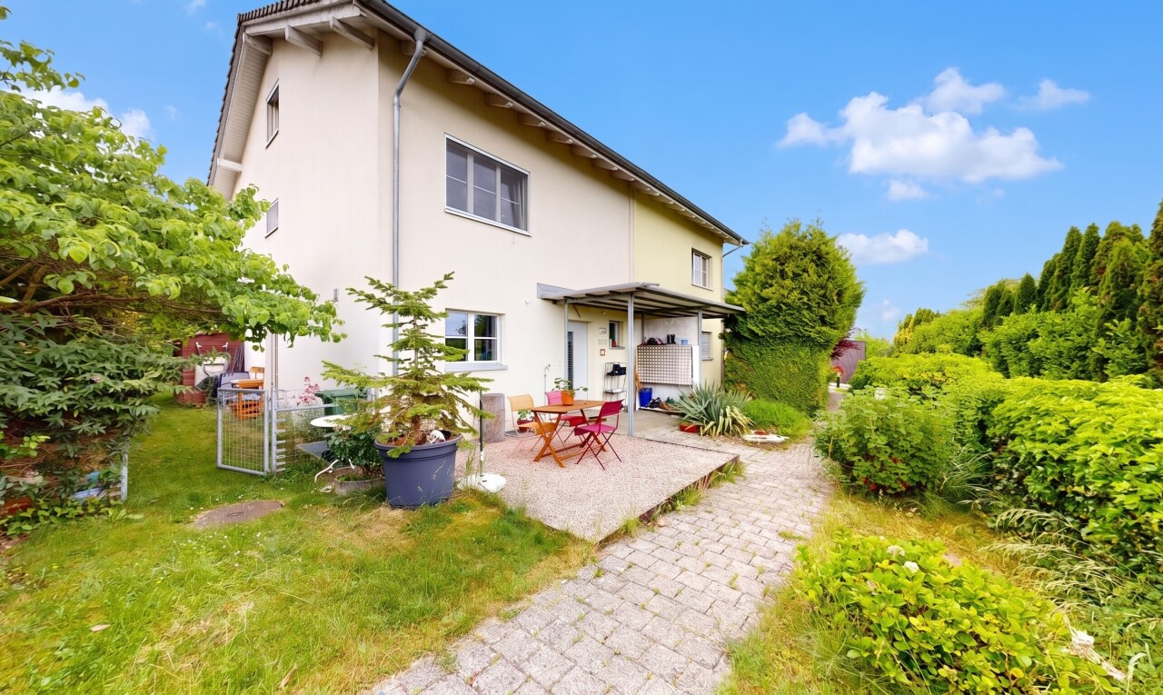 façade avec property visible, terrasse, bardage en stuc, pelouse, et day time