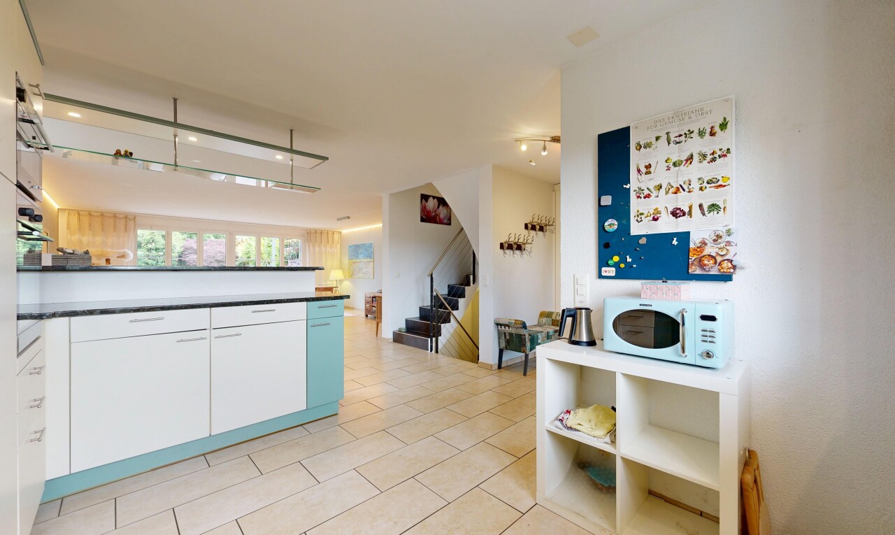 cuisine avec two heights countertops, light floor, inside property, ouvert sur l'espace de vie, et opens to living area