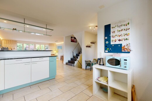 cuisine avec two heights countertops, light floor, inside property, ouvert sur l'espace de vie, et opens to living area