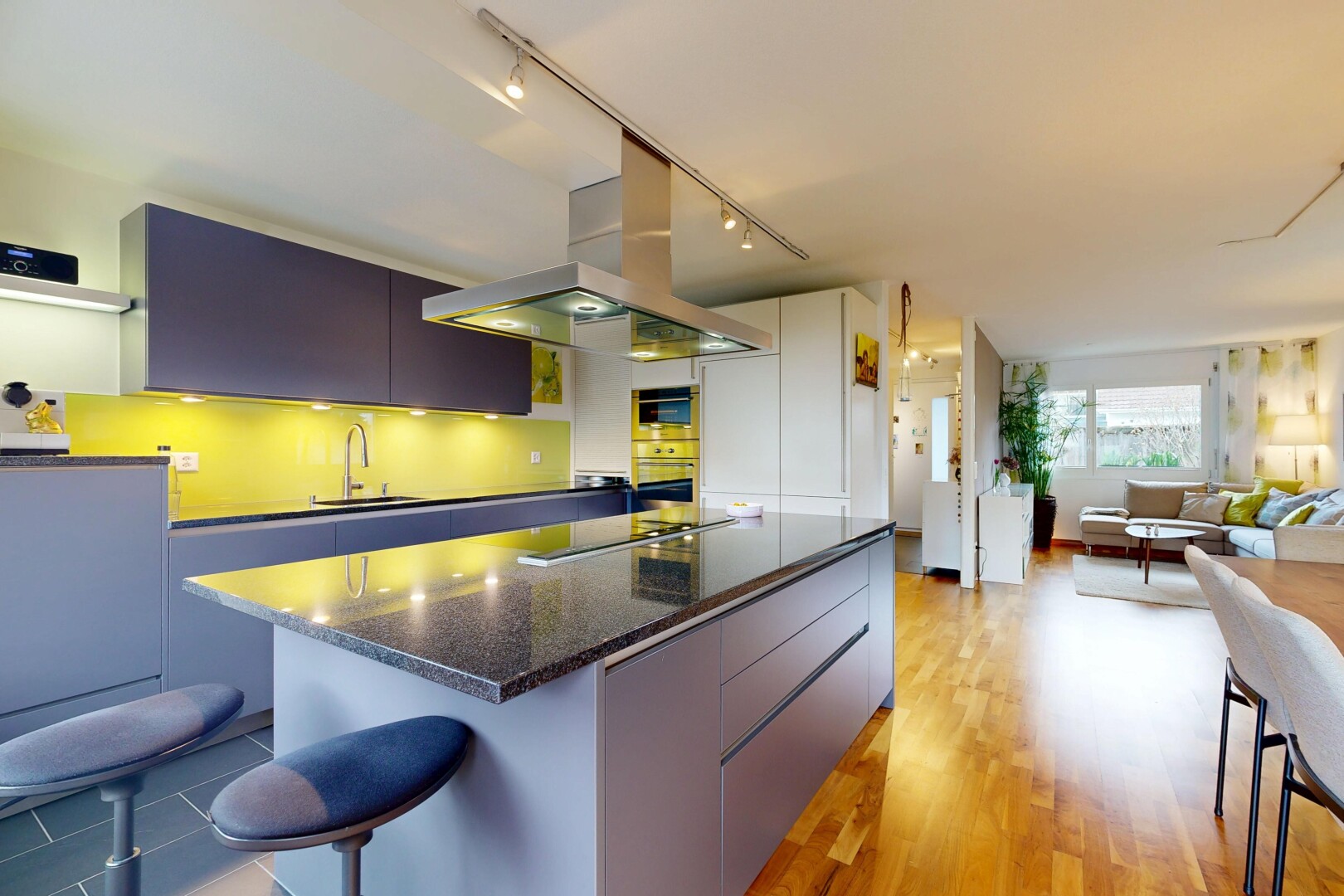 kitchen featuring a breakfast bar, a kitchen island, track lighting, modern cabinets, and light wood-type flooring
