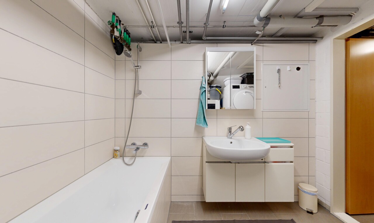 bathroom featuring vanity, tile walls, and bathing tub / shower combination