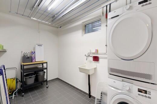 buanderie avec cloison sèche, drywall, buanderie, inside property, et lave-linge et sèche-linge superposés