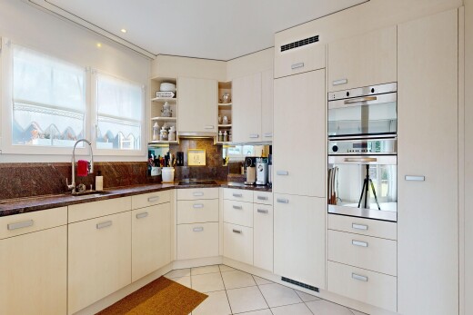 cuisine avec étagères ouvertes, open shelves, light floor, dark countertops, et lumière naturelle