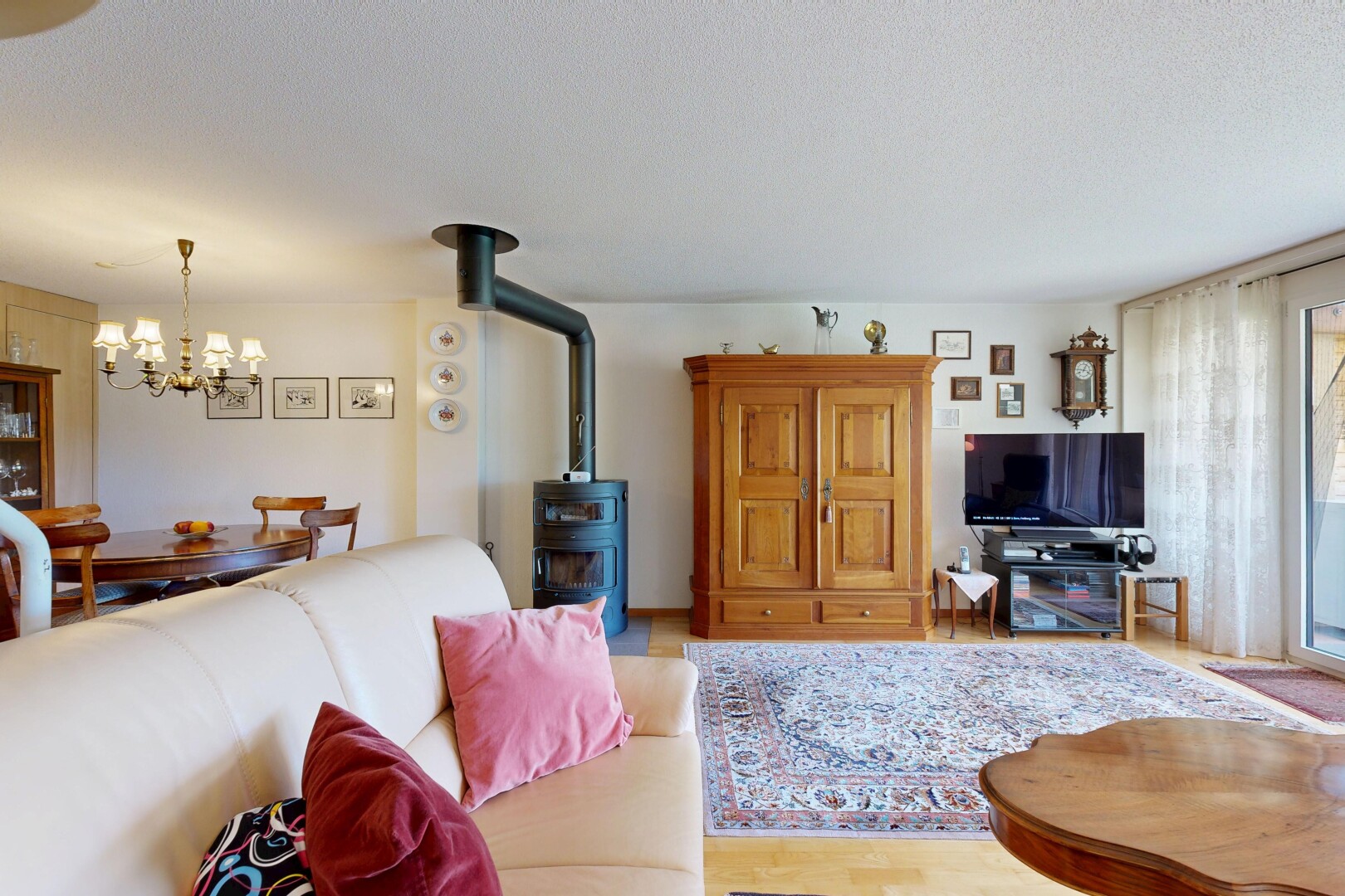 salon / salle à manger avec inside property, poêle à bois, télévision, wood finish floor, et sol en finition bois