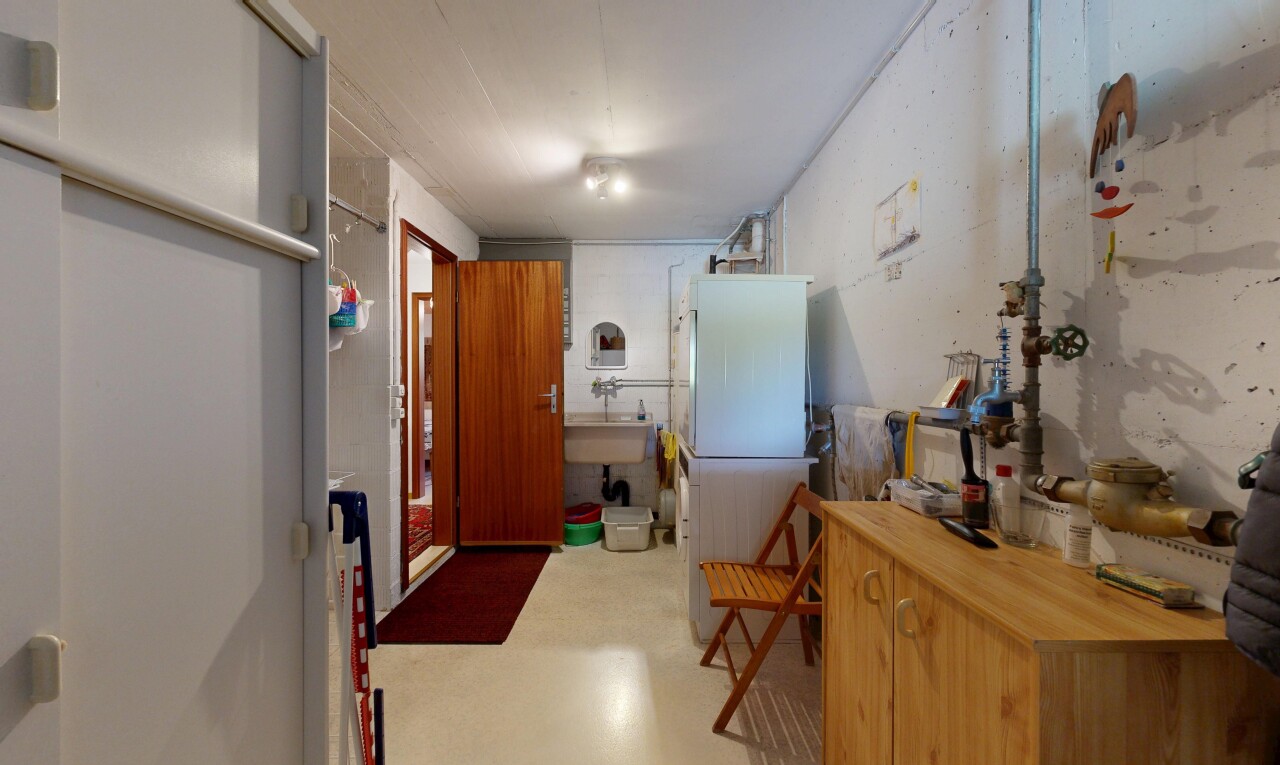 buanderie avec inside property, light floor, évier, concrete floor, et sol en béton