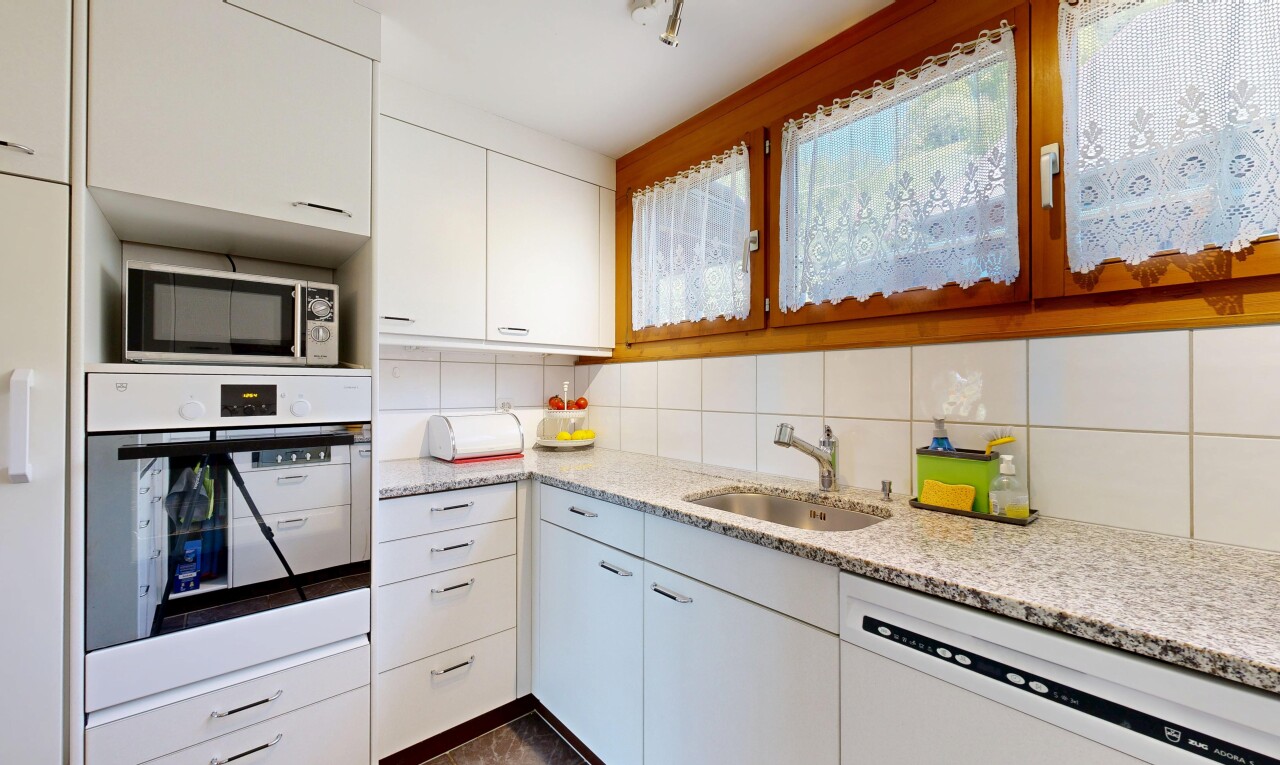 cuisine avec four, light countertops, armoires blanches, white cabinets, et dark floor