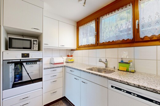 cuisine avec four, light countertops, armoires blanches, white cabinets, et dark floor