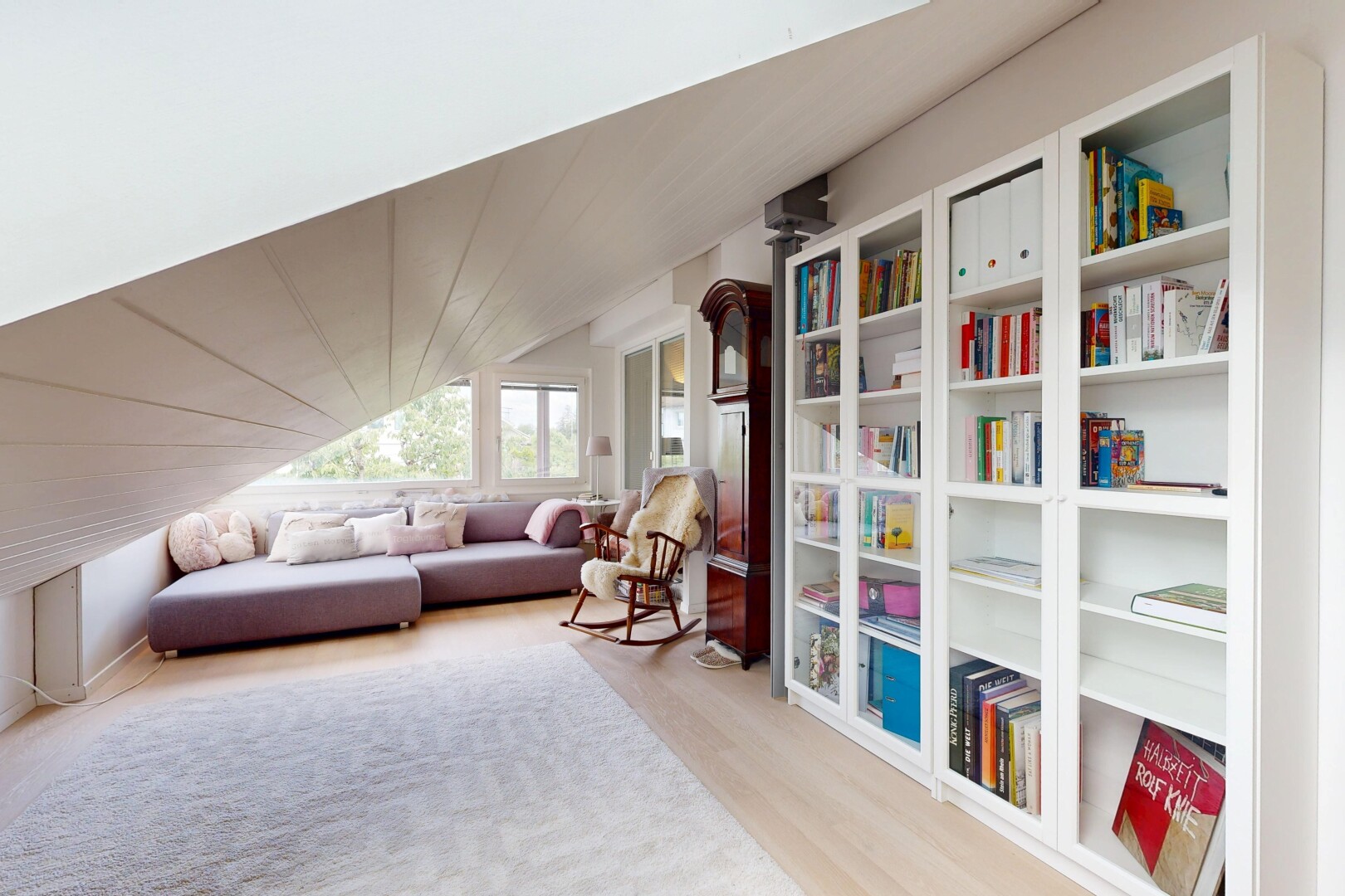 wohnzimmer mit eingebaute regale, vaulted ceiling, dachschräge, wood finish floor, und holzfußboden