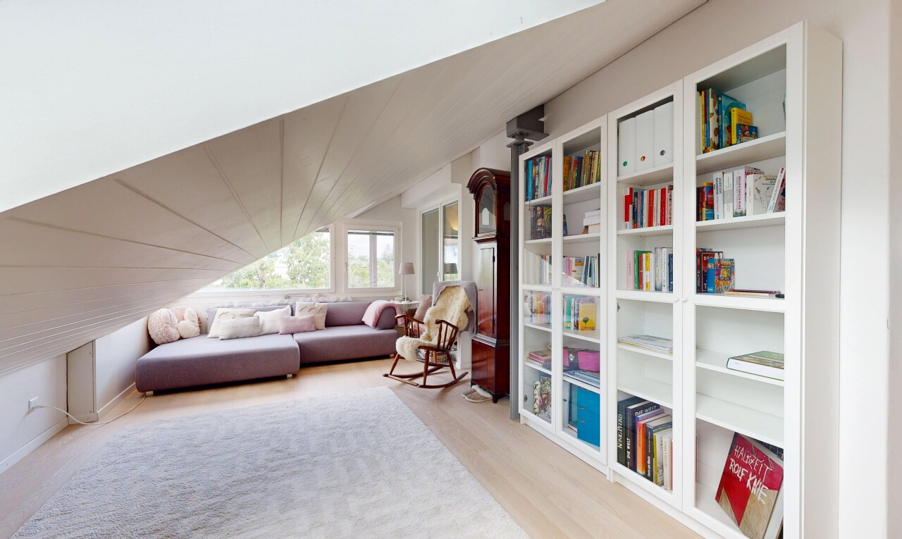 wohnzimmer mit eingebaute regale, vaulted ceiling, dachschräge, wood finish floor, und holzfußboden