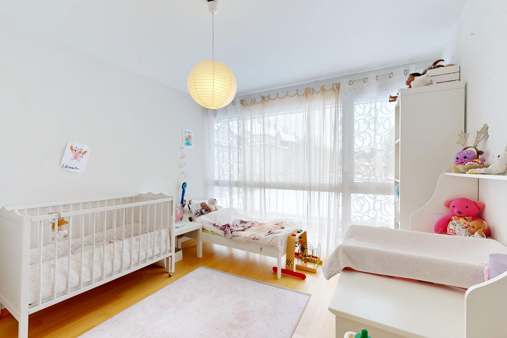 room / bedroom featuring a crib and wood finished floors
