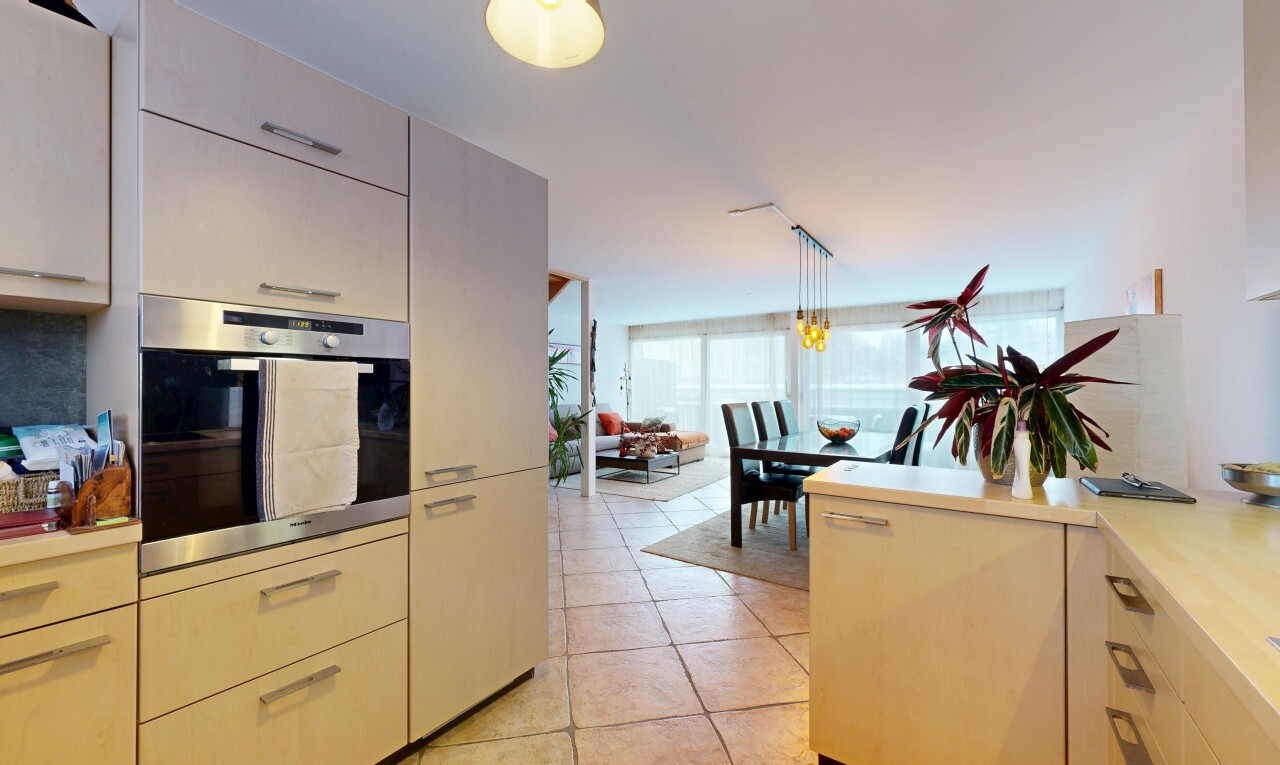 kitchen with stainless steel oven, pendant lighting, healthy amount of natural light, and light tile patterned flooring