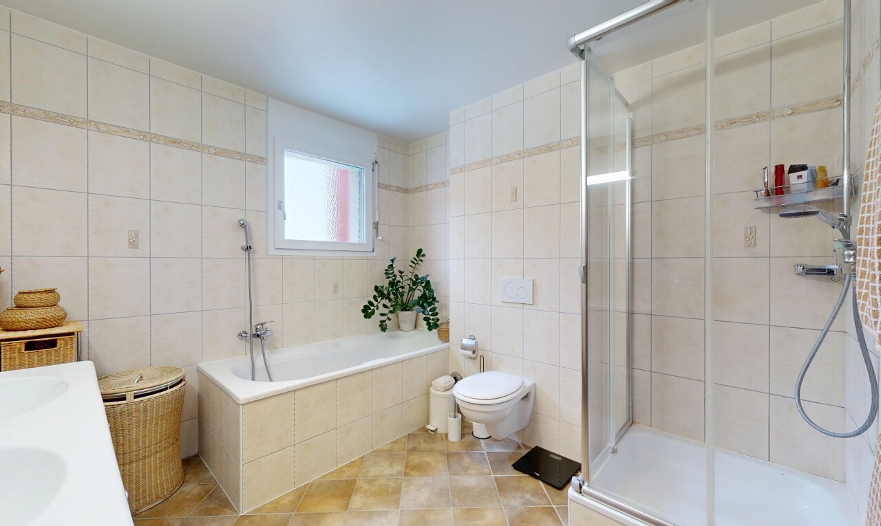 bathroom featuring tile walls, a shower stall, vanity, light tile patterned flooring, and tiled tub