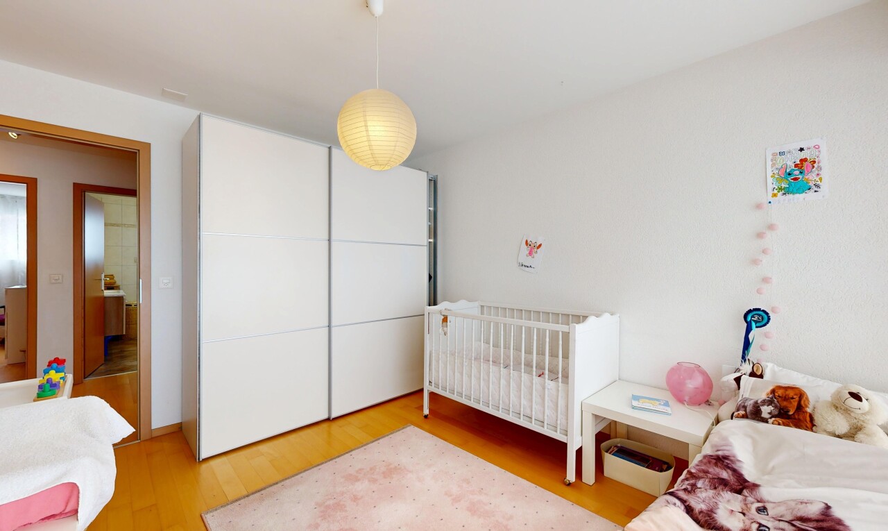 room featuring light wood-style flooring and a nursery area