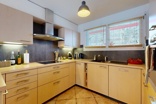 cuisine avec dosseret, backsplash, plans de travail, hotte, et lumière naturelle