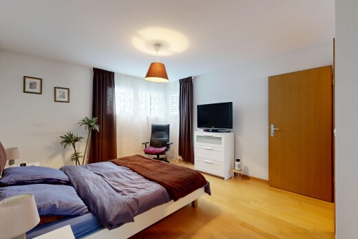 chambre avec sol en finition bois, wood finish floor, télévision, inside property, et cloison sèche