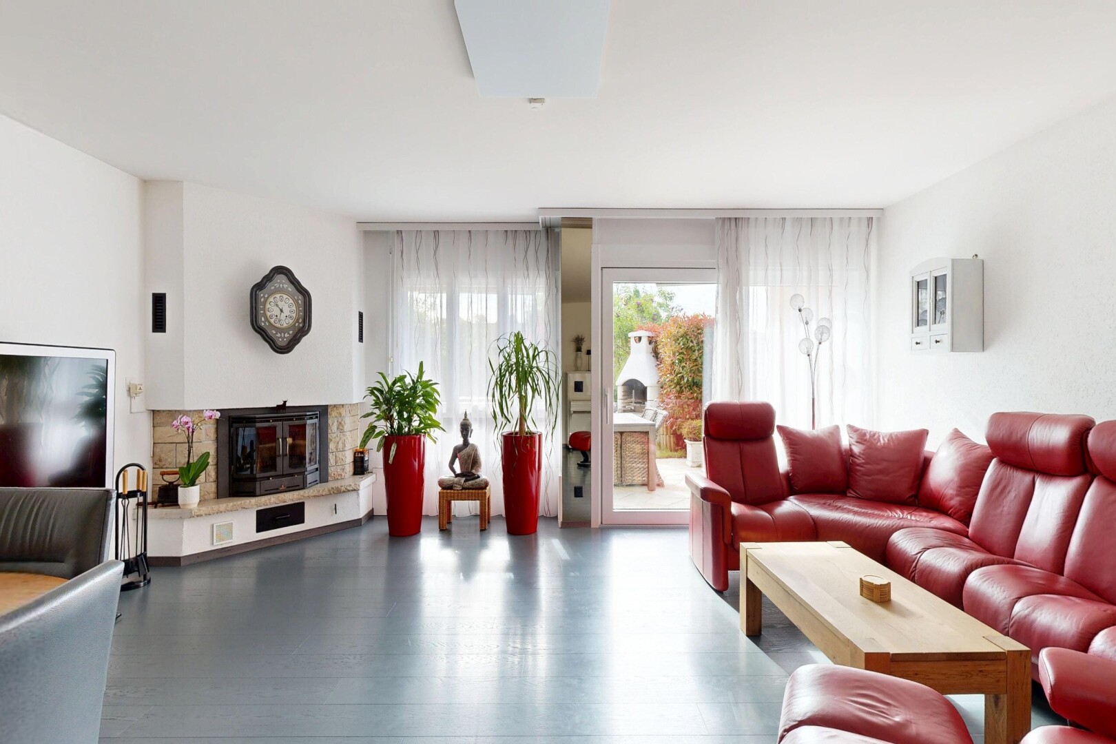 living area featuring a glass covered fireplace and wood finished floors