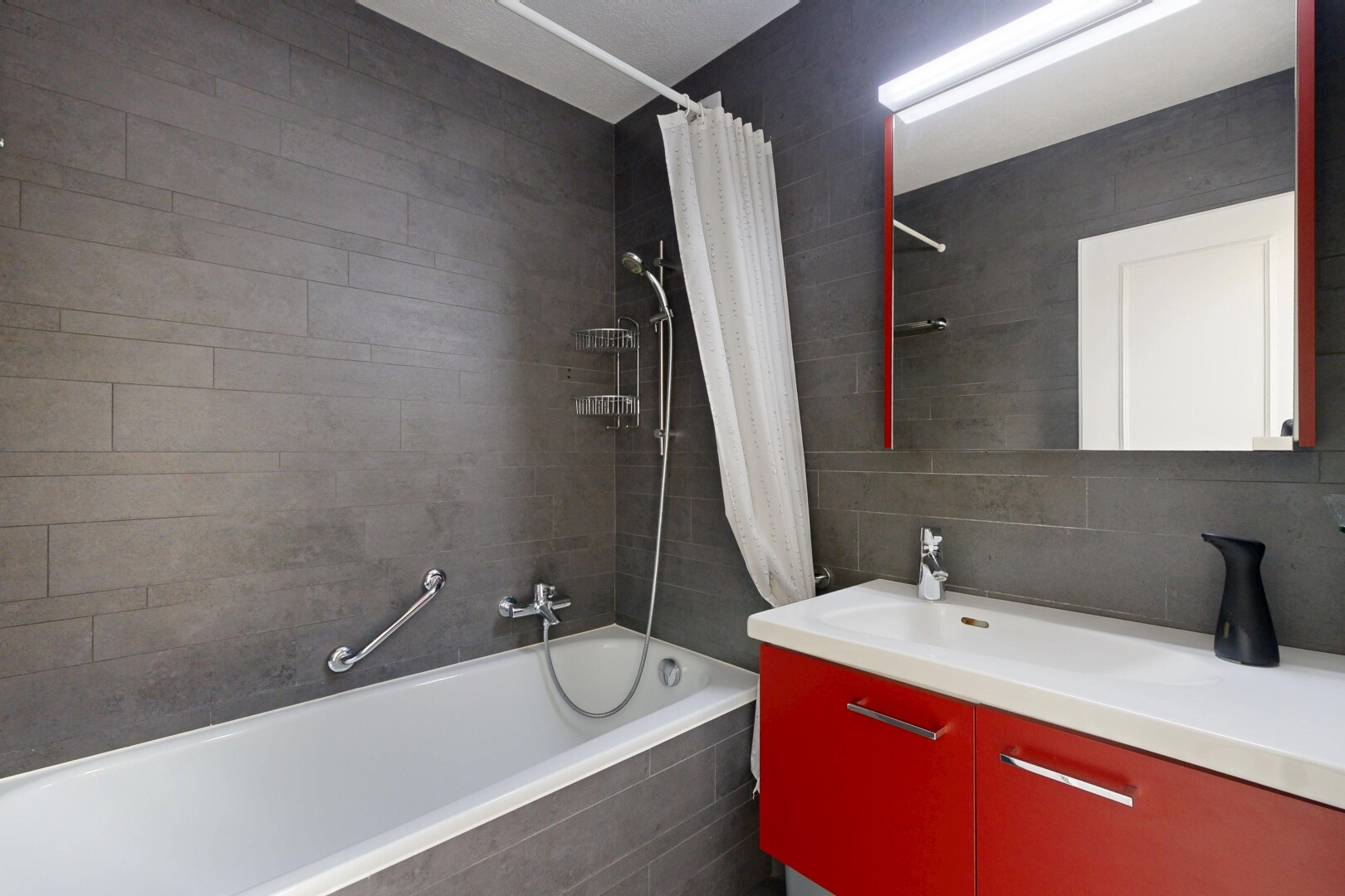 bathroom featuring vanity, tiled shower / bath, tile walls, and tasteful backsplash