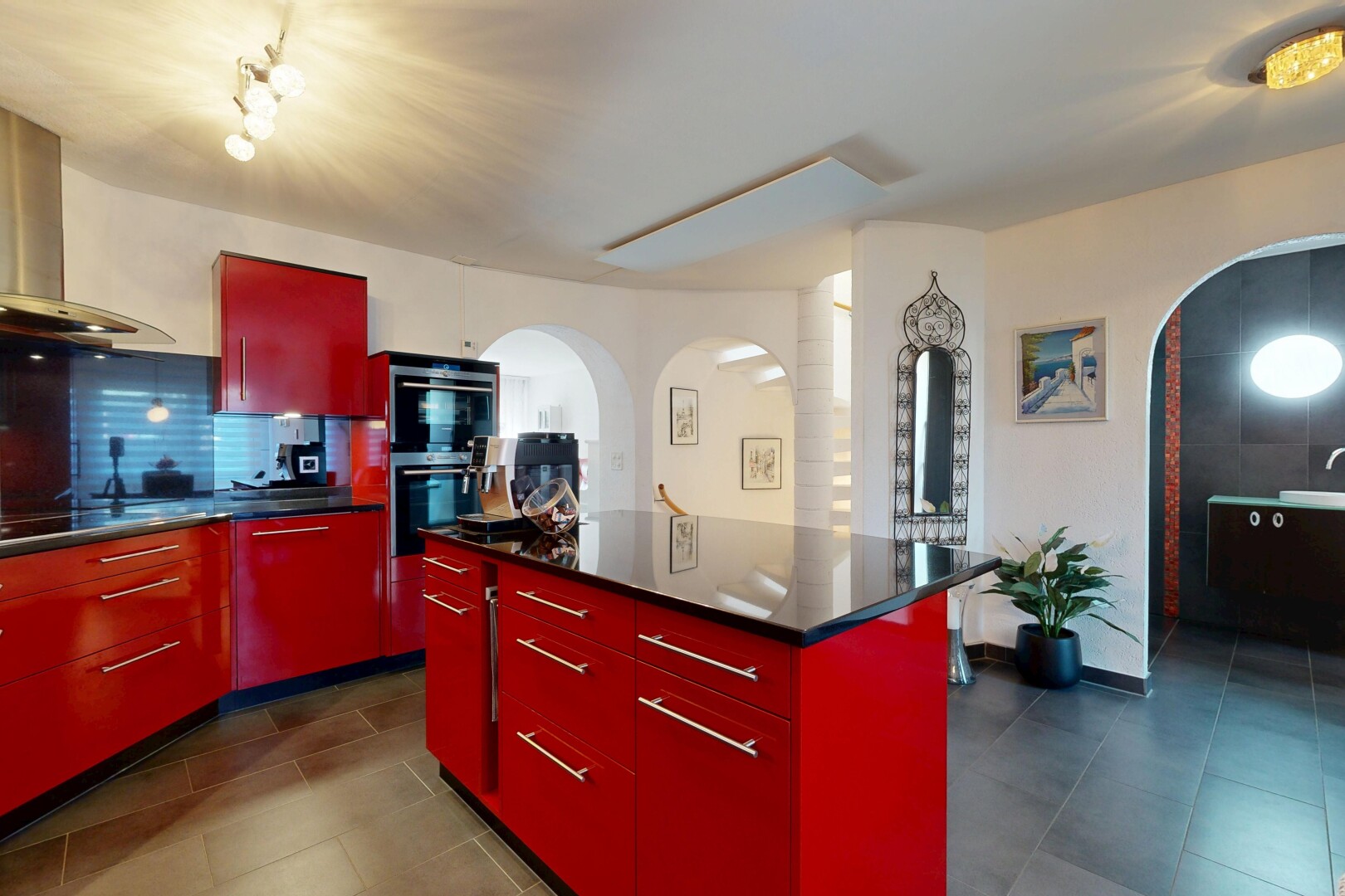 kitchen with red cabinets, arched walkways, modern cabinets, a kitchen island, and decorative backsplash