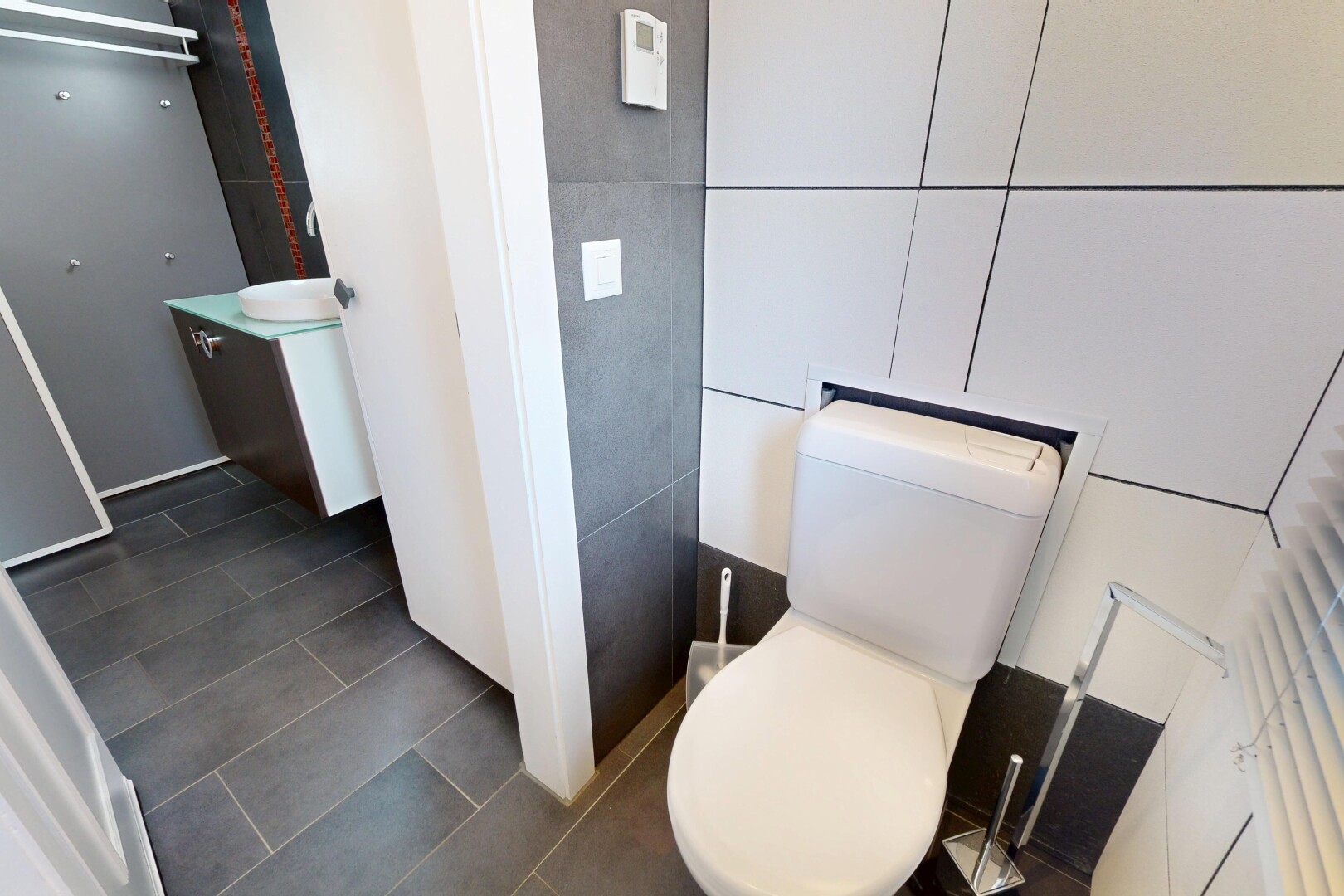 half bath featuring vanity, dark tile patterned flooring, and tile walls