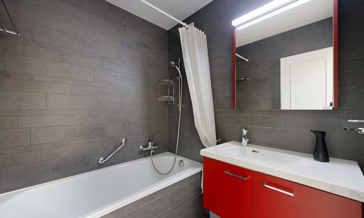 bathroom featuring vanity, tiled shower / bath, tile walls, and tasteful backsplash