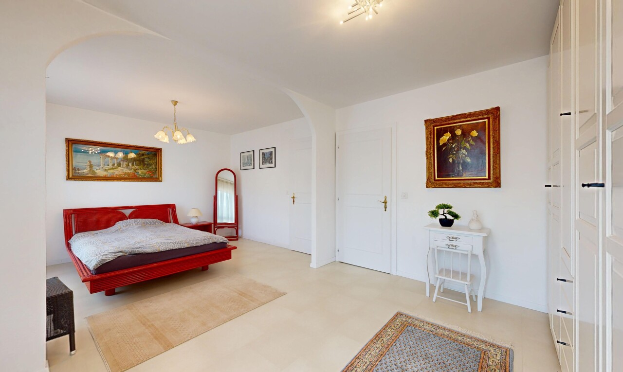 room / bedroom featuring arched walkways, a chandelier, and light flooring