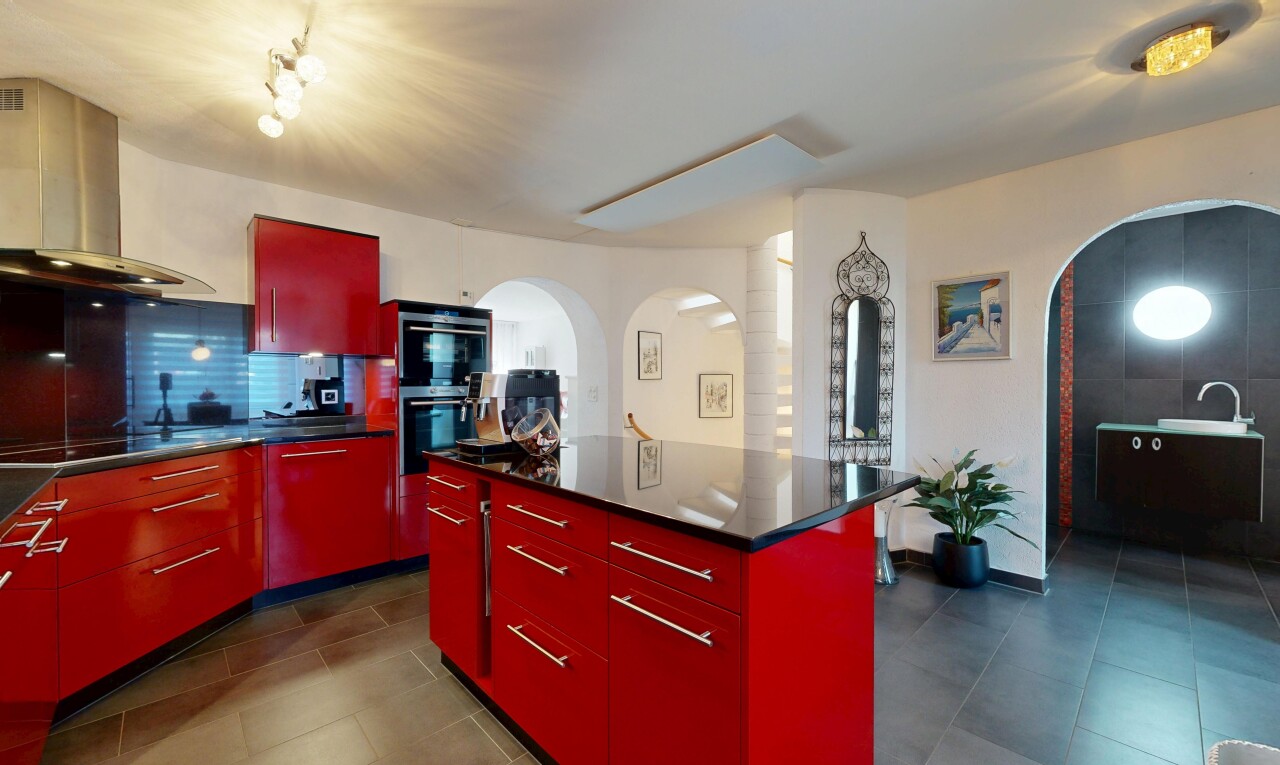 kitchen with red cabinets, arched walkways, modern cabinets, a kitchen island, and decorative backsplash
